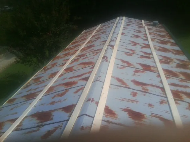 Rusted metal roof panels with new wood purlins before replacement — Storm Damage Roof Repair in Creston by Roofing Brothers