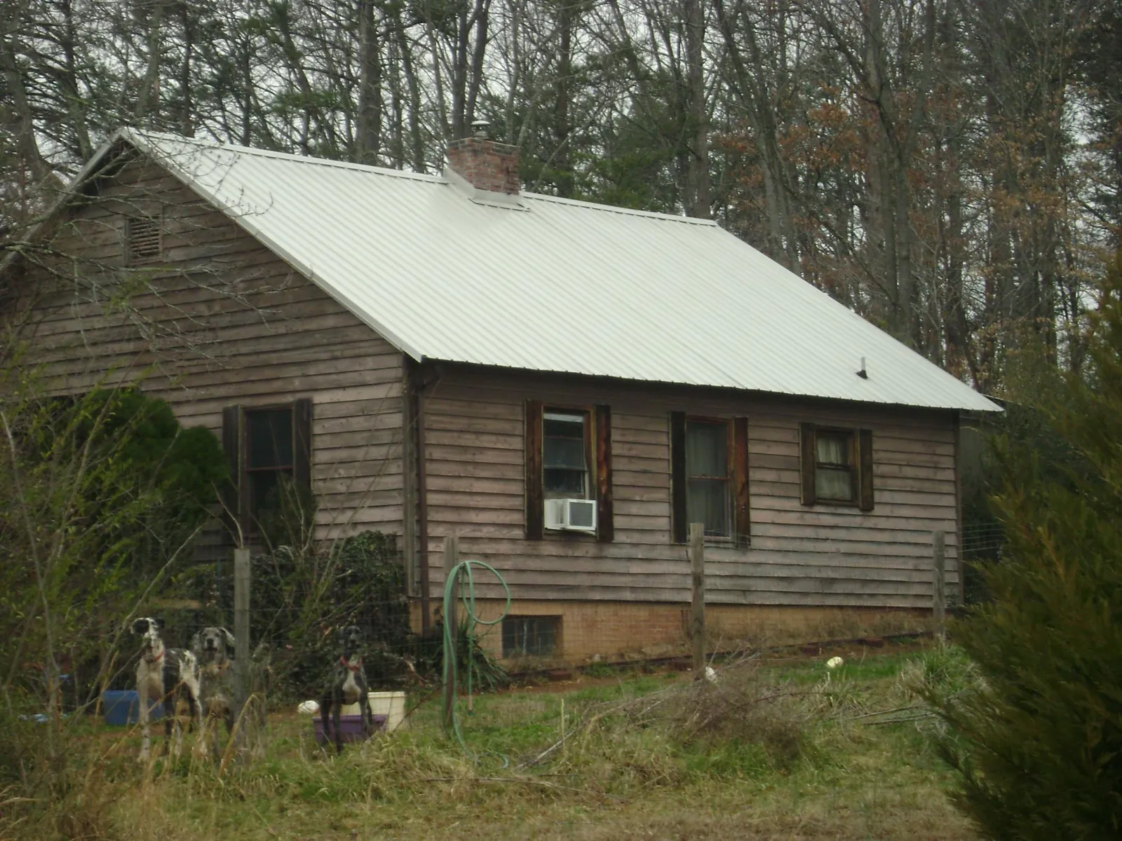 White metal roof on an old wood sided farmhouse, from a Metal Roof Installation job in Creston